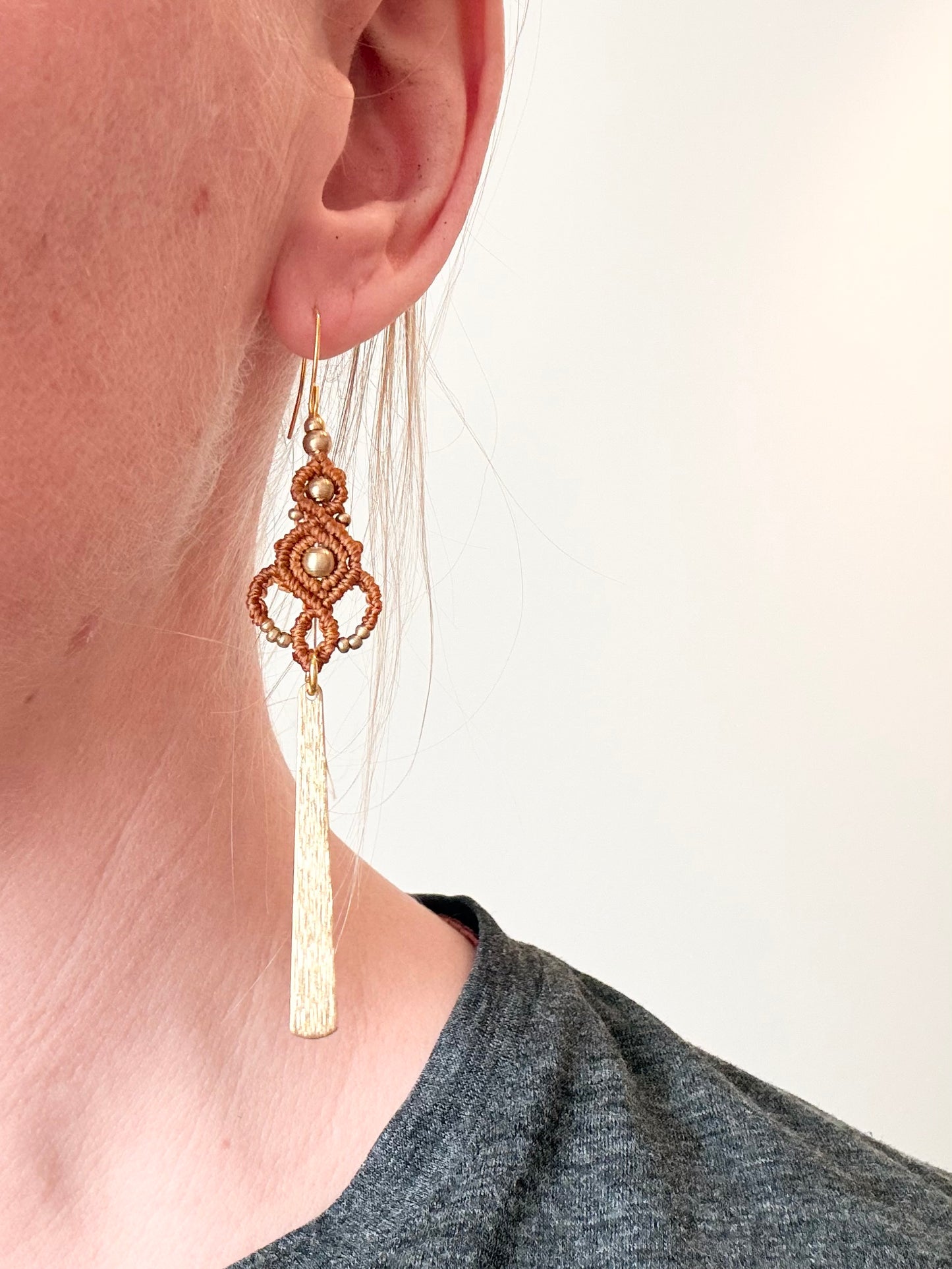 Golden rhythm - Lange handgemaakte macramé oorbellen met messing kralen en hanger