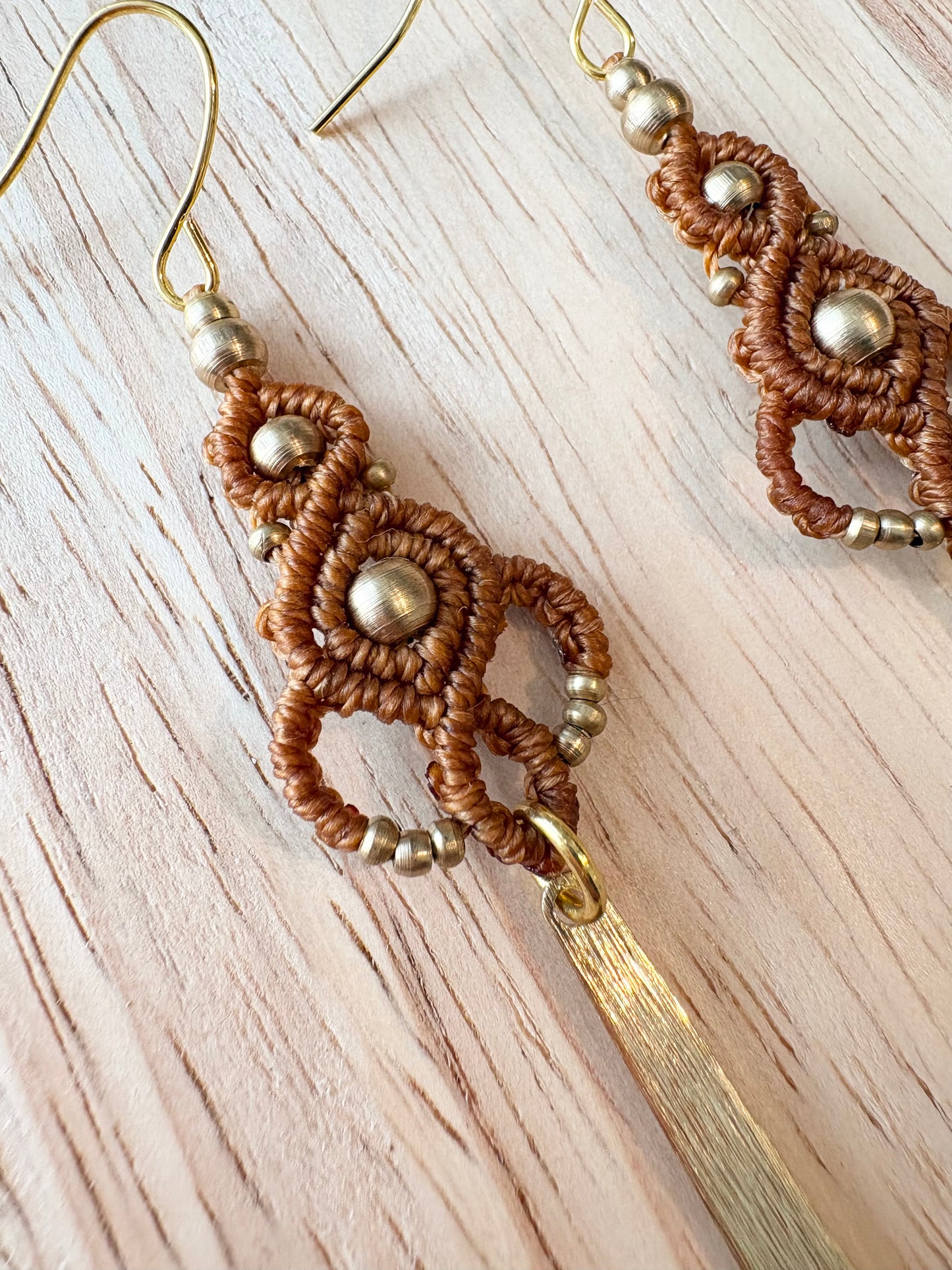 Golden rhythm - Lange handgemaakte macramé oorbellen met messing kralen en hanger